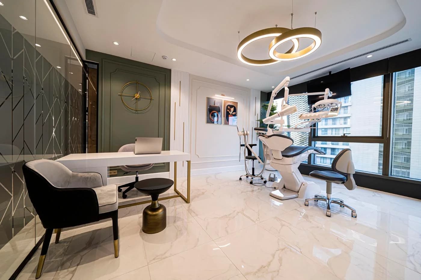 Treatment room at Auradentis with green panelling, a dental unit and a dentist's desk